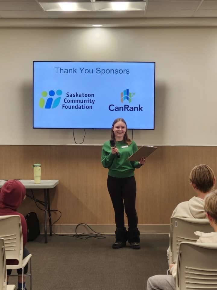 A youth committee member thanking sponsors on stage